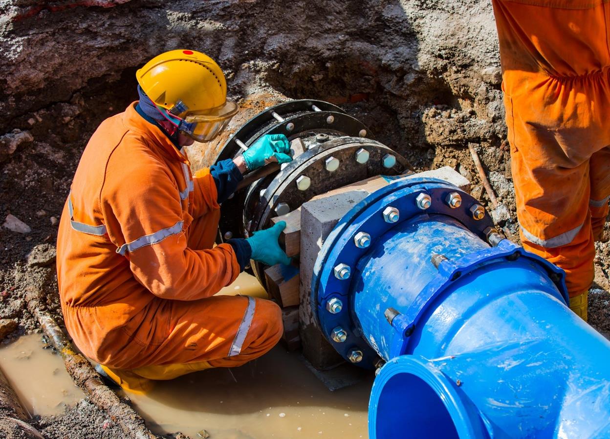 Worker holding a white safety helmet on site